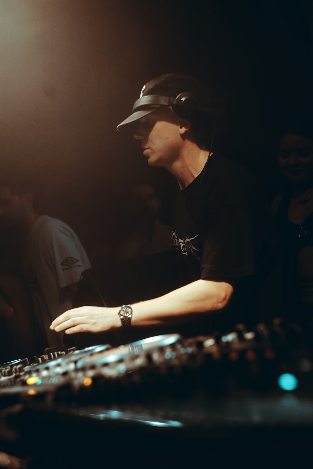 dj-wearing-headphones-and-hat-at-the-turntables-x-gnwoa0hzs