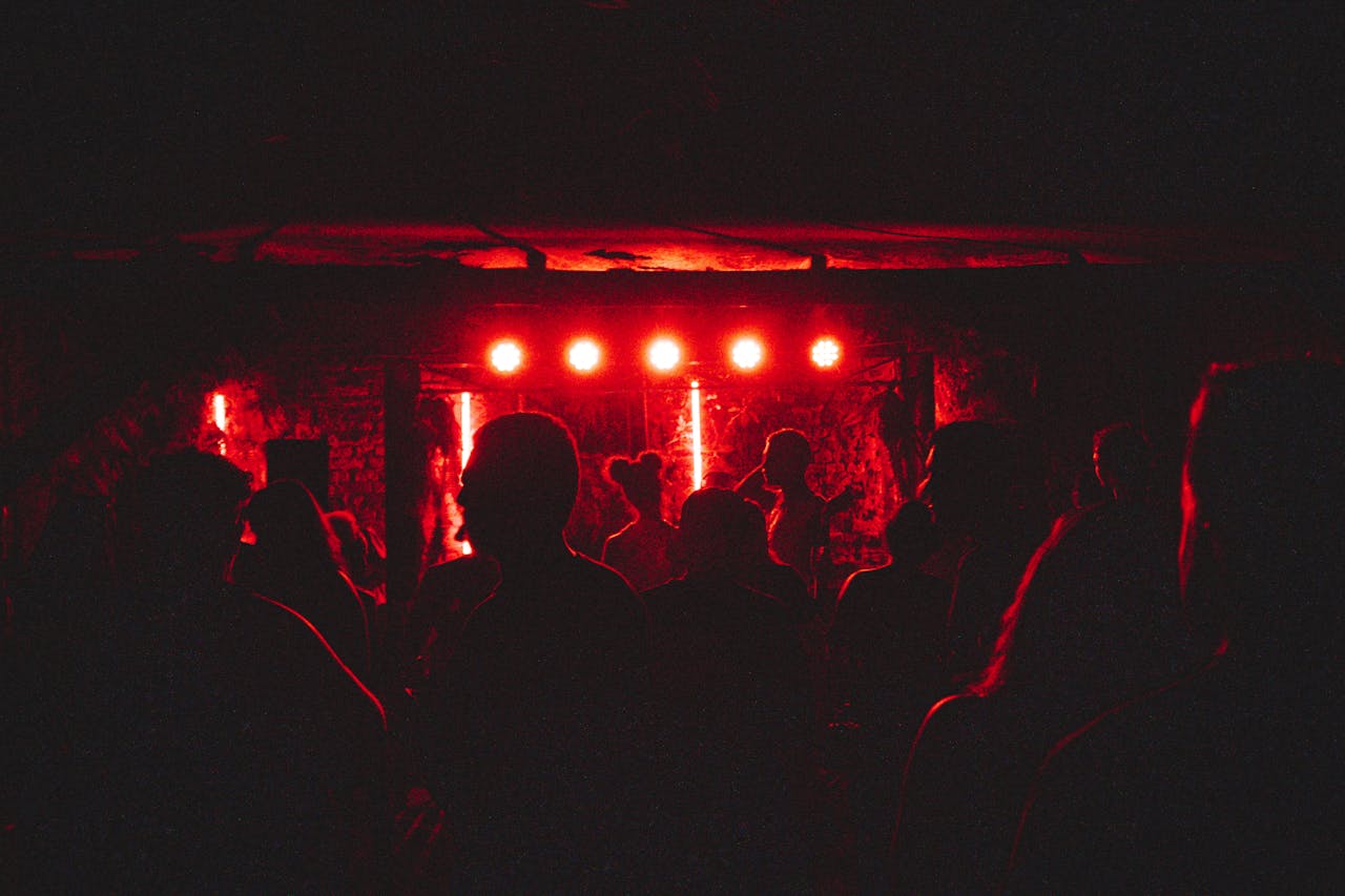 Dynamic crowd enjoying live music performance with intense red lighting on stage.